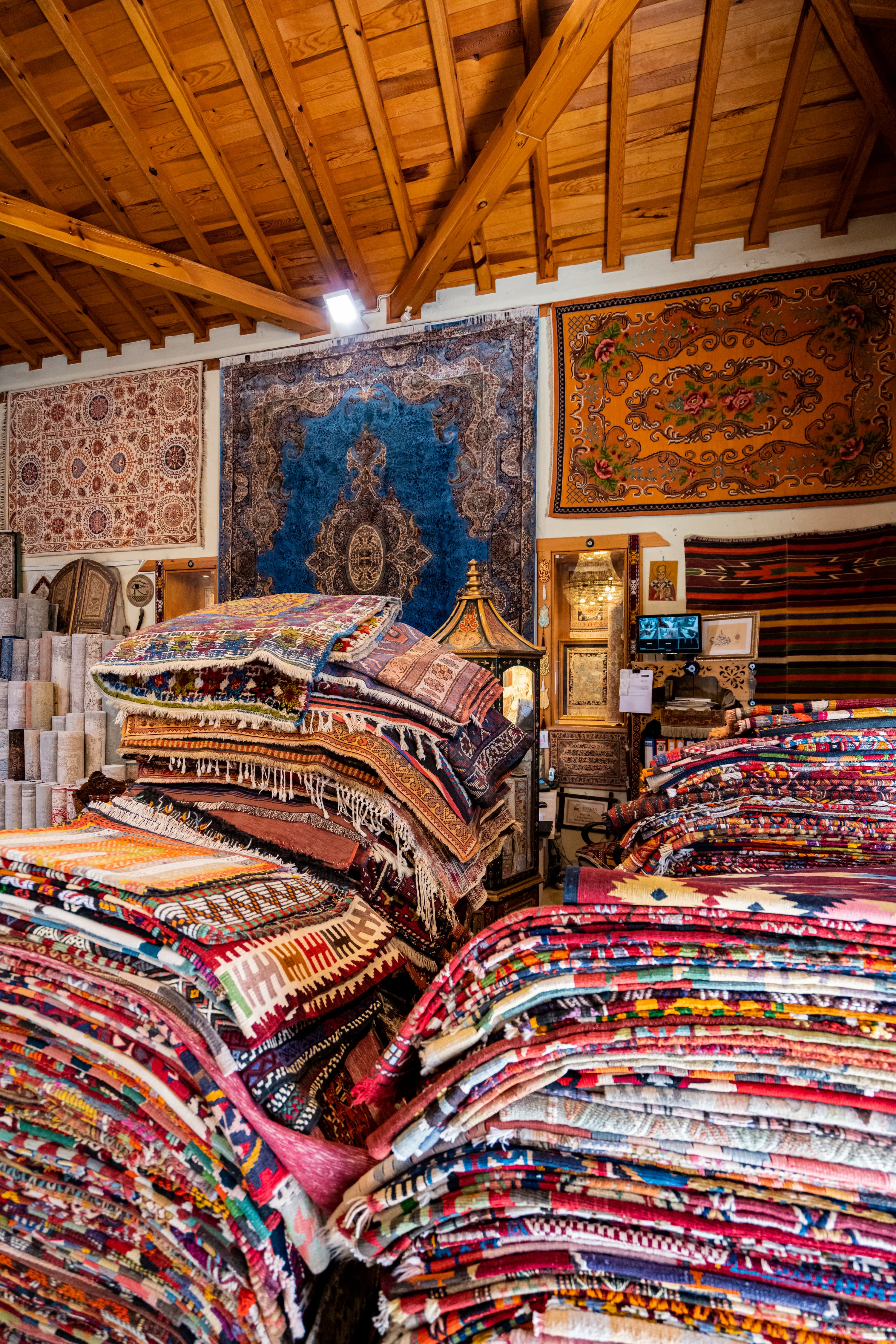 Colorful stacked rugs in traditional carpet shop interior