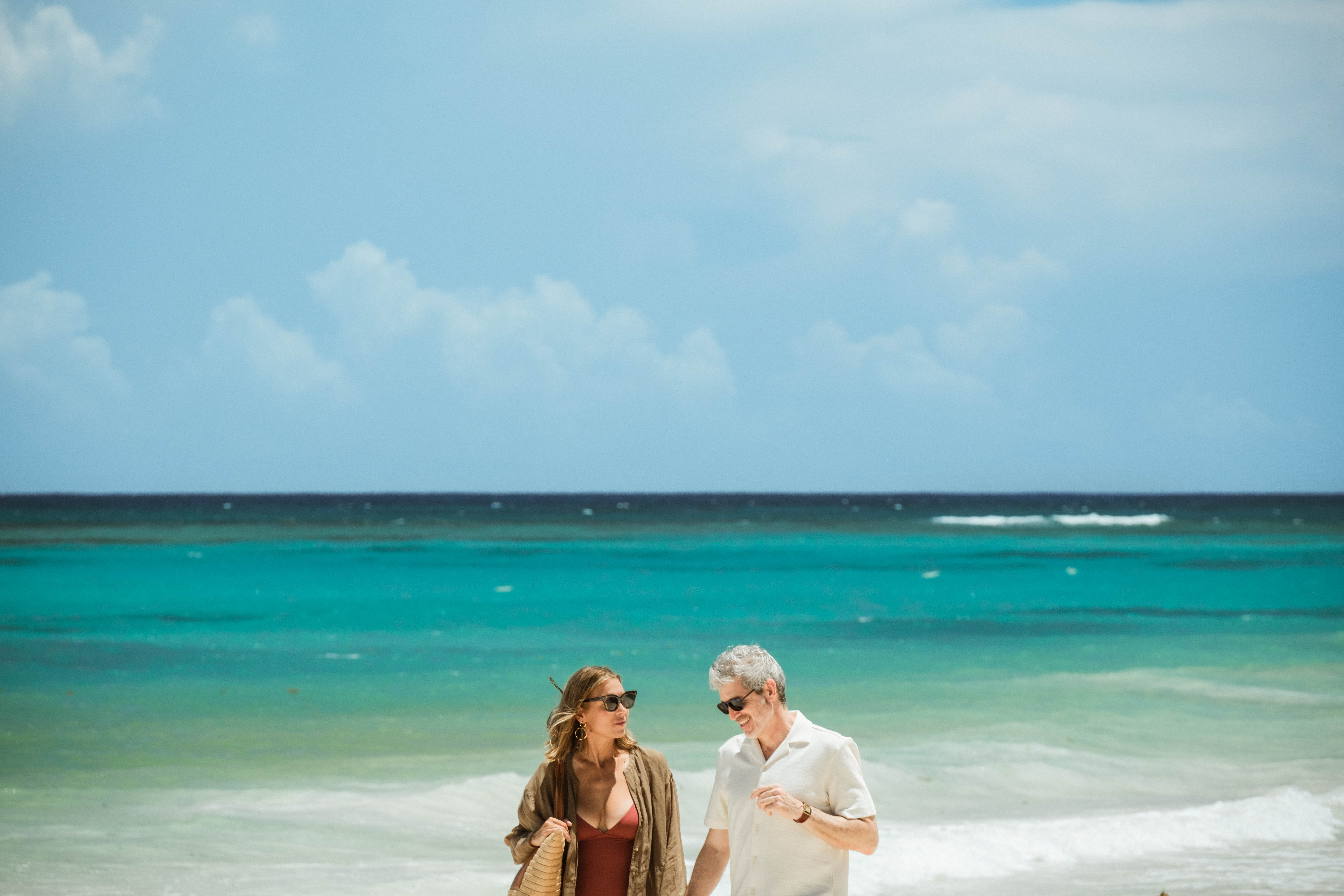 Couple walking together on tropical beach shoreline