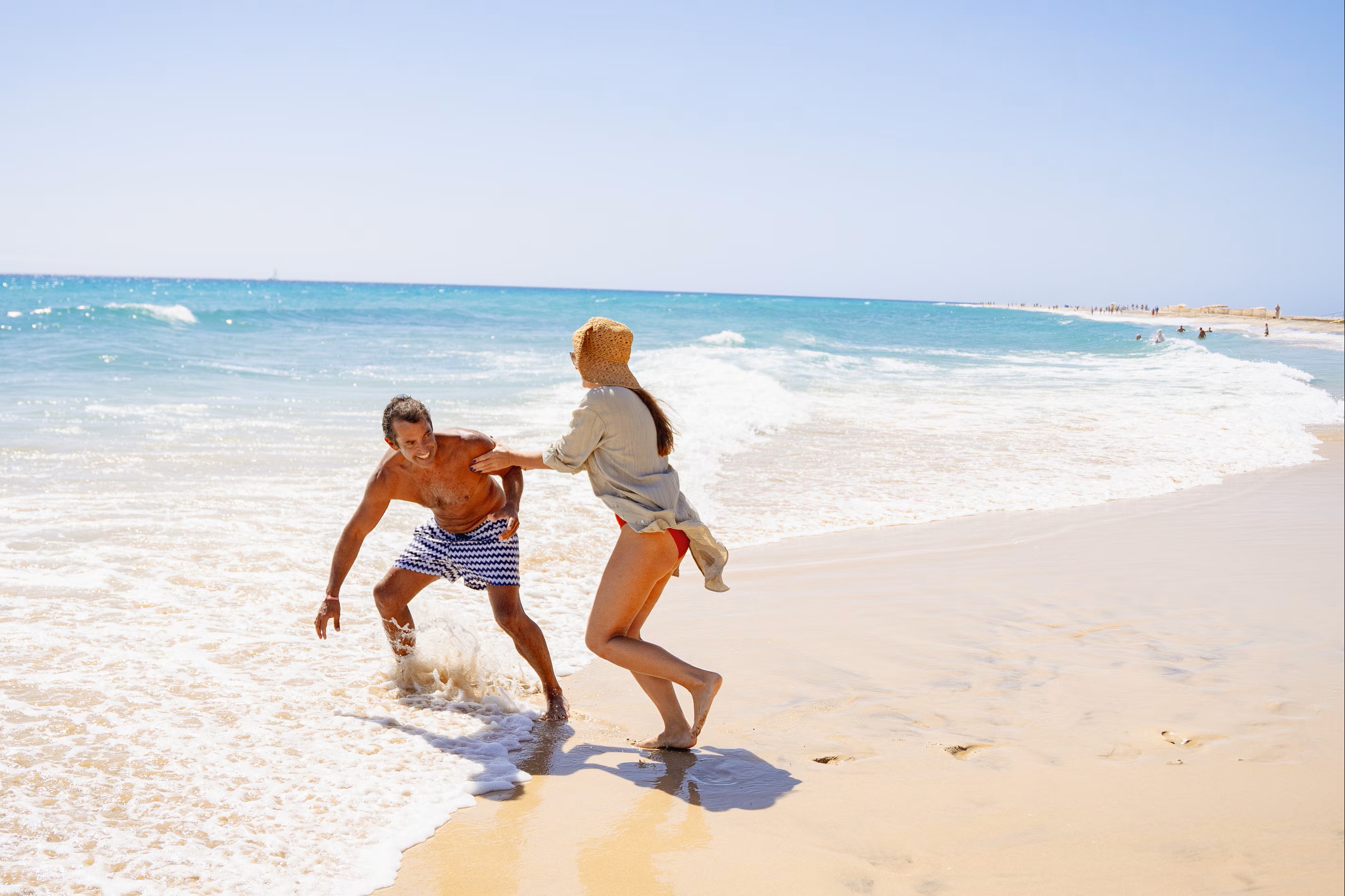 Playful couple enjoying sunny day at the beach